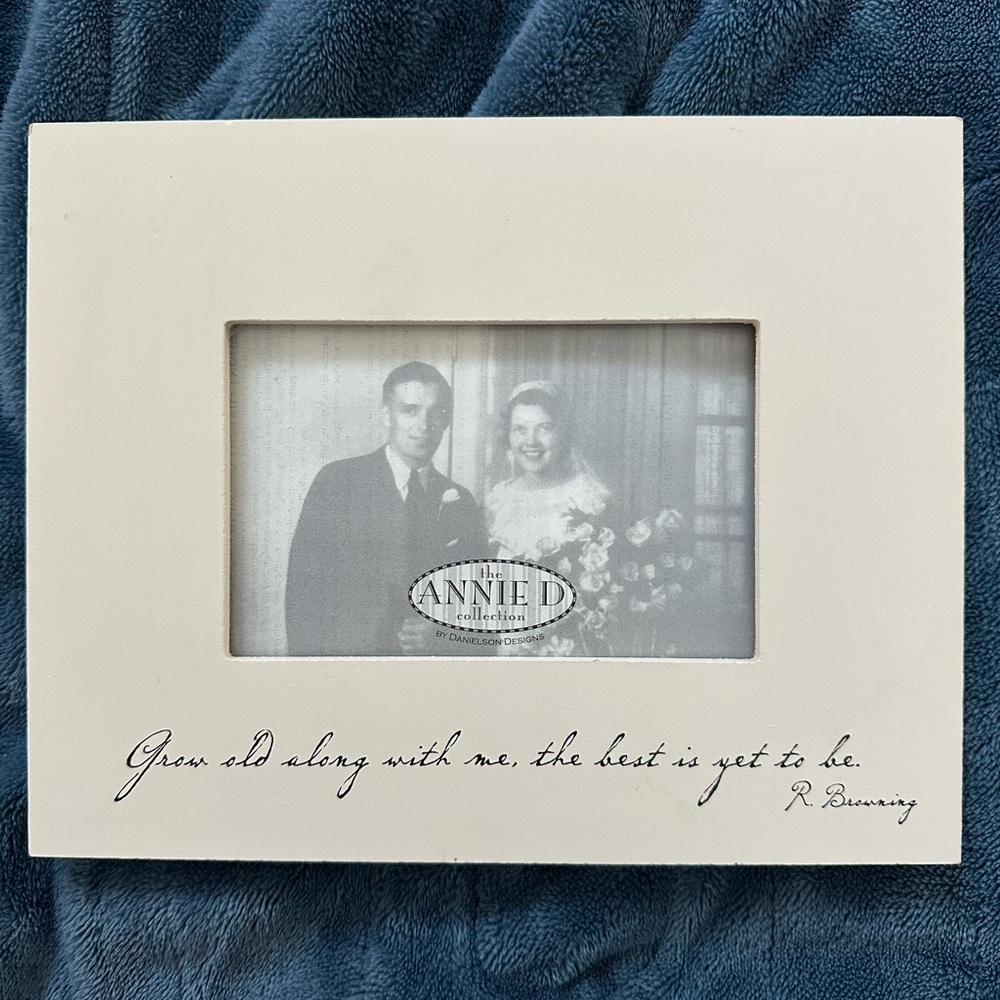 Creamy off-white wooden picture frame with engraved black cursive writing